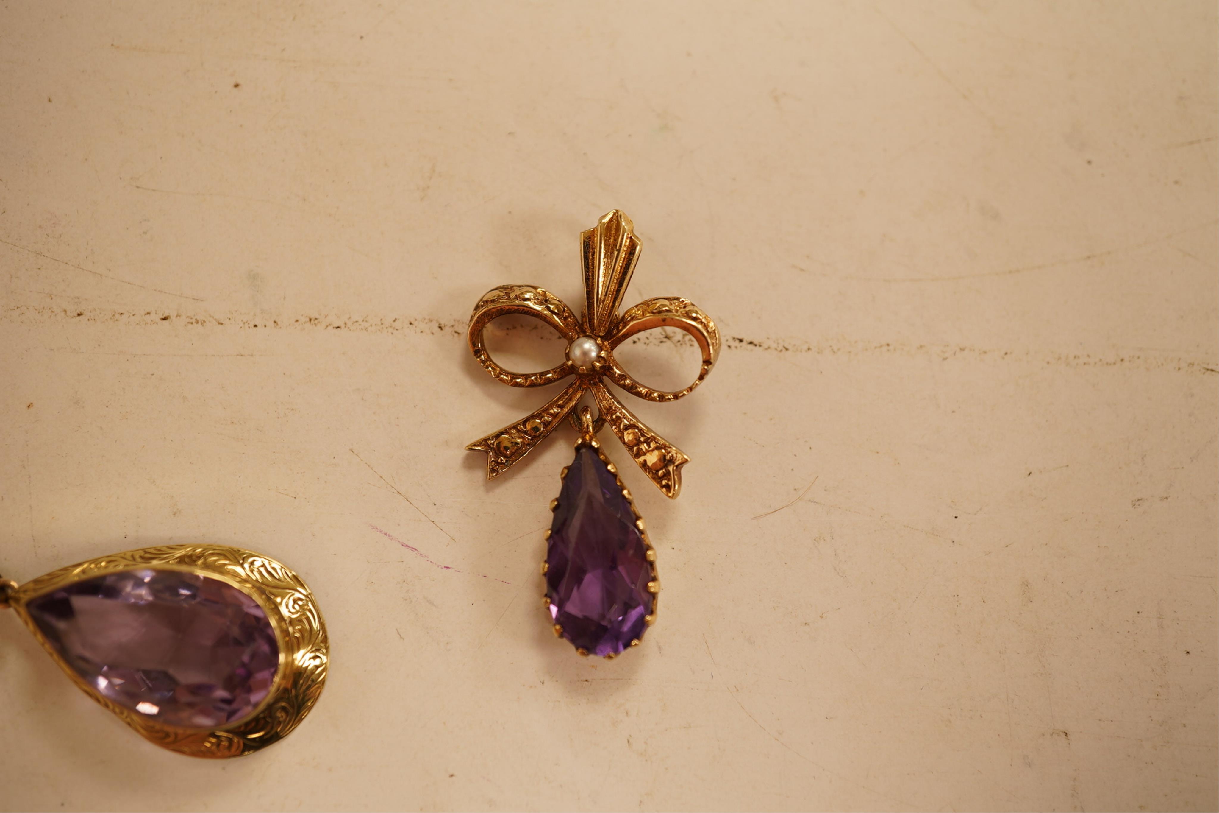 A 1970's 9ct gold, amethyst and seed pearl set drop pendant, 29mm, together with a yellow meta and amethyst set drop pendant.